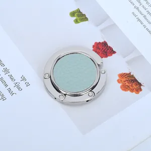 Close-up of portable foldable bag hanger with light blue leather inlay