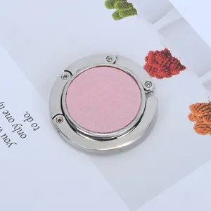 Detail view of a creative portable pink leather and metal foldable desk bag hook