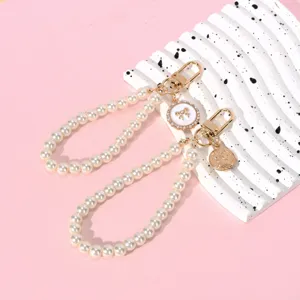 Macro shot of elegant pearl lanyards featuring golden clasps and stylish charms