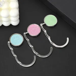 Close-up of portable foldable circular bag hooks in glittery blue, pink, and green