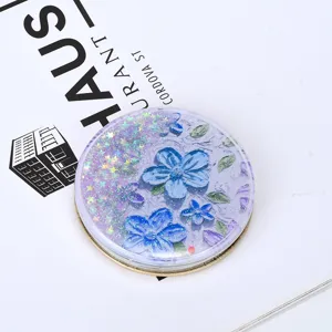 Close-up of quicksand makeup mirror with blue flower relief and purple glitter