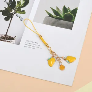Detail shot of a yellow mango and smiley face charm for phone or bags