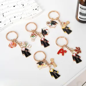 Close-up of various graduation gown keychains with diploma and bachelor cap charms for gifts.
