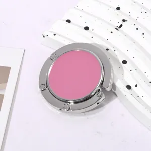 Gedetailleerde weergave van de inklapbare roze tassenhaak met zilveren metalen rand