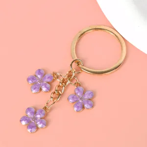 Detailed macro shot of elegant purple cherry blossom flower charms on a gold metal keychain
