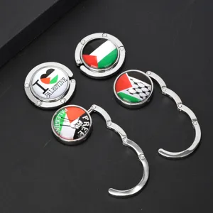Detail view of foldable metal purse hooks with Palestinian flag designs and slogans