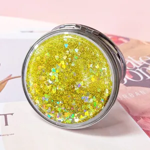 Close-up detail of yellow glitter heart-shaped sequins in a round pocket mirror