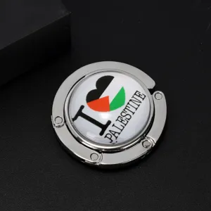 Close-up of a foldable metal handbag hook featuring an I Love Palestine flag design