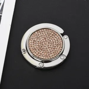 Detailansicht der glitzernden rosa Strasssteine auf einem runden Metall-Taschenhalter