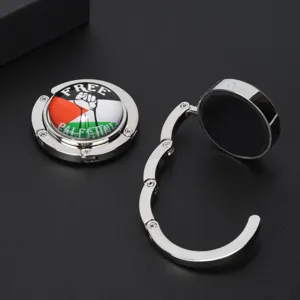 Detail of foldable metal bag hook featuring Palestine flag and FREE PALESTINE logo.