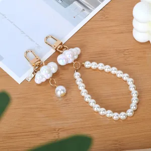 Detalle del lindo llavero para bolso con nube iridiscente y perlas blancas.