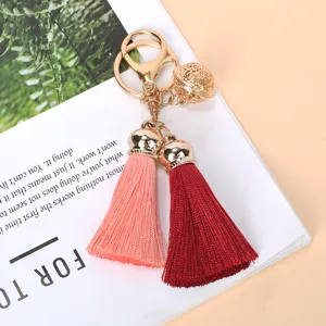 Close-up detail of golden bell and dual tassels in pink and burgundy red