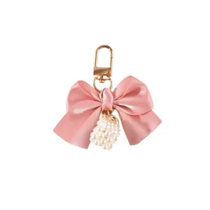 Cute pink ribbon bow keychain with a white pearl cube charm and gold metal clasp.