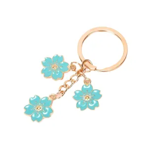 Elegant gold-tone keychain featuring three beautiful blue enamel cherry blossom flower charms.