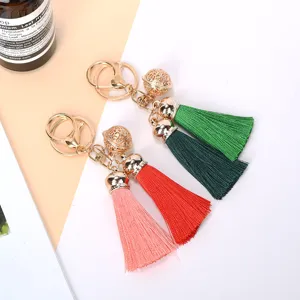 Close-up of elegant double tassel keychains with intricate hollow-out golden bell detail