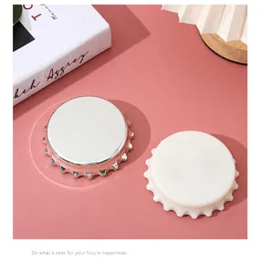 Detalle de abridores magnéticos con forma de tapón en acabados plata y blanco