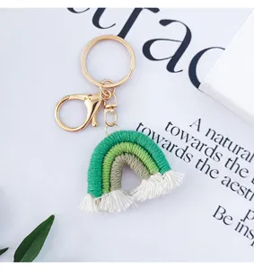 Gros plan d'un porte-clés arc-en-ciel vert tissé main avec fermoir doré.