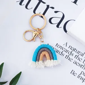 Gros plan d'un porte-clés arc-en-ciel en macramé fait main avec des pompons blancs