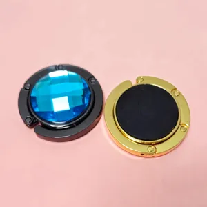 Detailed view of portable folding purse hooks with blue crystal and golden metal