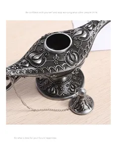 Detailed close-up of an antique silver Aladdin lamp with intricate floral embossed patterns