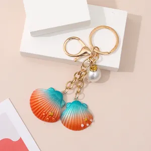 Creative resin seashell keychain with gradient orange blue colors and a white pearl charm
