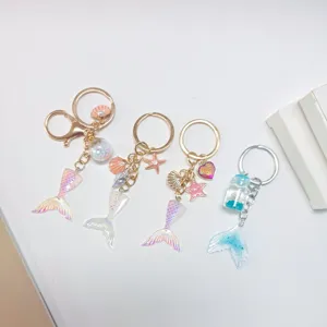 Collection of gradient mermaid tail keychains featuring seashell and starfish charms for women