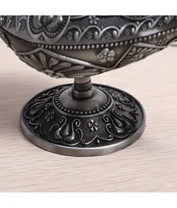 Close-up detail of vintage ornate metal Aladdin lamp base with intricate embossing