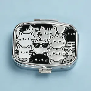 Detailed top-down view of a rectangular silver metal pill box featuring cute embossed cat patterns
