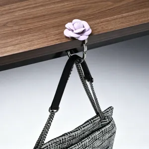 Detailweergave van draagbare roze roos decoratieve tashaak aan een houten bureau