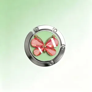 Detailaufnahme eines Taschenhalters aus Metall mit einem rosa Kristallschmetterling