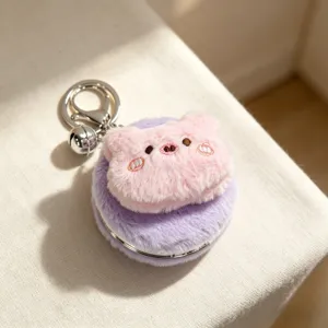 Dettaglio di specchio in peluche viola con testa di animale rosa e comodo portachiavi