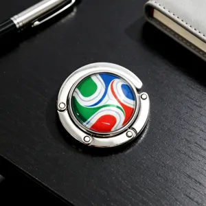 Detailansicht eines faltbaren Taschenhalters aus Metall mit Fußballmuster auf Tisch
