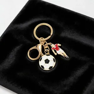 Detailed shot of a gold-toned metal soccer keychain with football and player charms