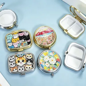 Close-up view of portable metal pill boxes with artistic cat and floral pattern lids