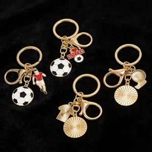Detailed view of golden soccer-themed metal keychains with football player charms.