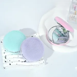 Dettaglio di specchietti compatti in peluche colorati a forma di macaron con texture morbida