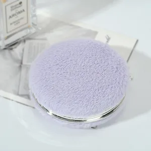 Primo piano dettagliato di uno specchio da trucco rotondo in pelliccia sintetica viola
