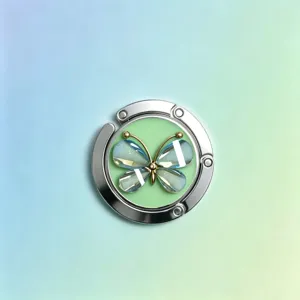 Detailansicht eines runden Metall-Handtaschenhakens mit einem schimmernden Schmetterling