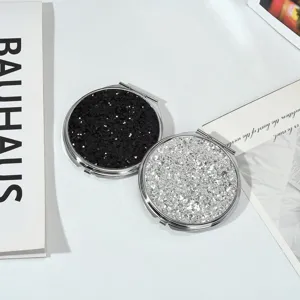 Gros plan de miroirs de poche en métal pailleté avec finitions noir et argent brillant