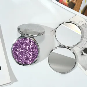 Vue détaillée de la surface pailletée violette et du miroir rond double face ouvert