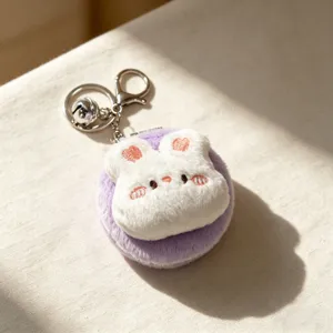 Dettaglio dello specchio da tasca a forma di coniglio in peluche viola con portachiavi.