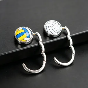 Detailansicht von zwei faltbaren Taschenhaltern aus Metall mit Volleyball-Design auf dunklem Grund.