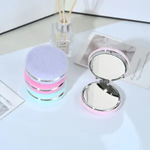 Primo piano di eleganti specchietti per il trucco rotondi in peluche in colori pastello