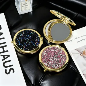 Macro view of gold metal folding mirrors with sparkling pink and blue rhinestone covers