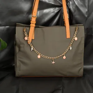 Détail de la chaîne de sac dorée avec breloques coquillage et étoile de mer