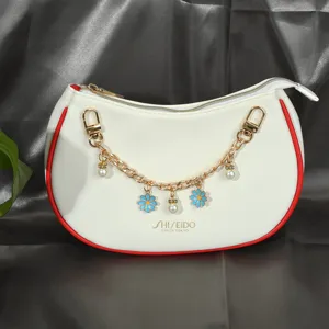 Vue détaillée d'une chaîne de sac en métal doré avec des fleurs bleues et des perles