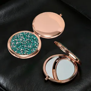 Detailed view of rose gold compact mirrors with green glitter and double-sided design
