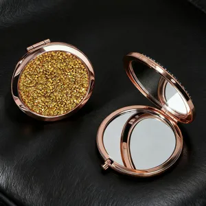 Detailed view of rose gold compact mirror with sparkling gold glitter and double mirrors.
