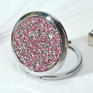 Detailed view of portable folding round makeup mirror with pink sparkling rhinestones