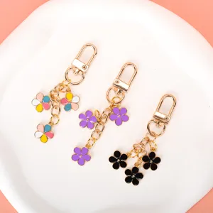 Set of three colorful enamel flower keychains with gold-tone metal hardware and lobster clasps.